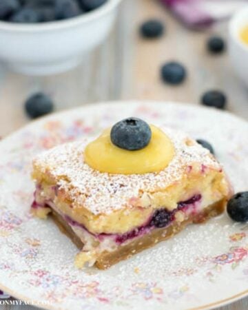 Serving blueberry dessert bars on a floral dessert plate.