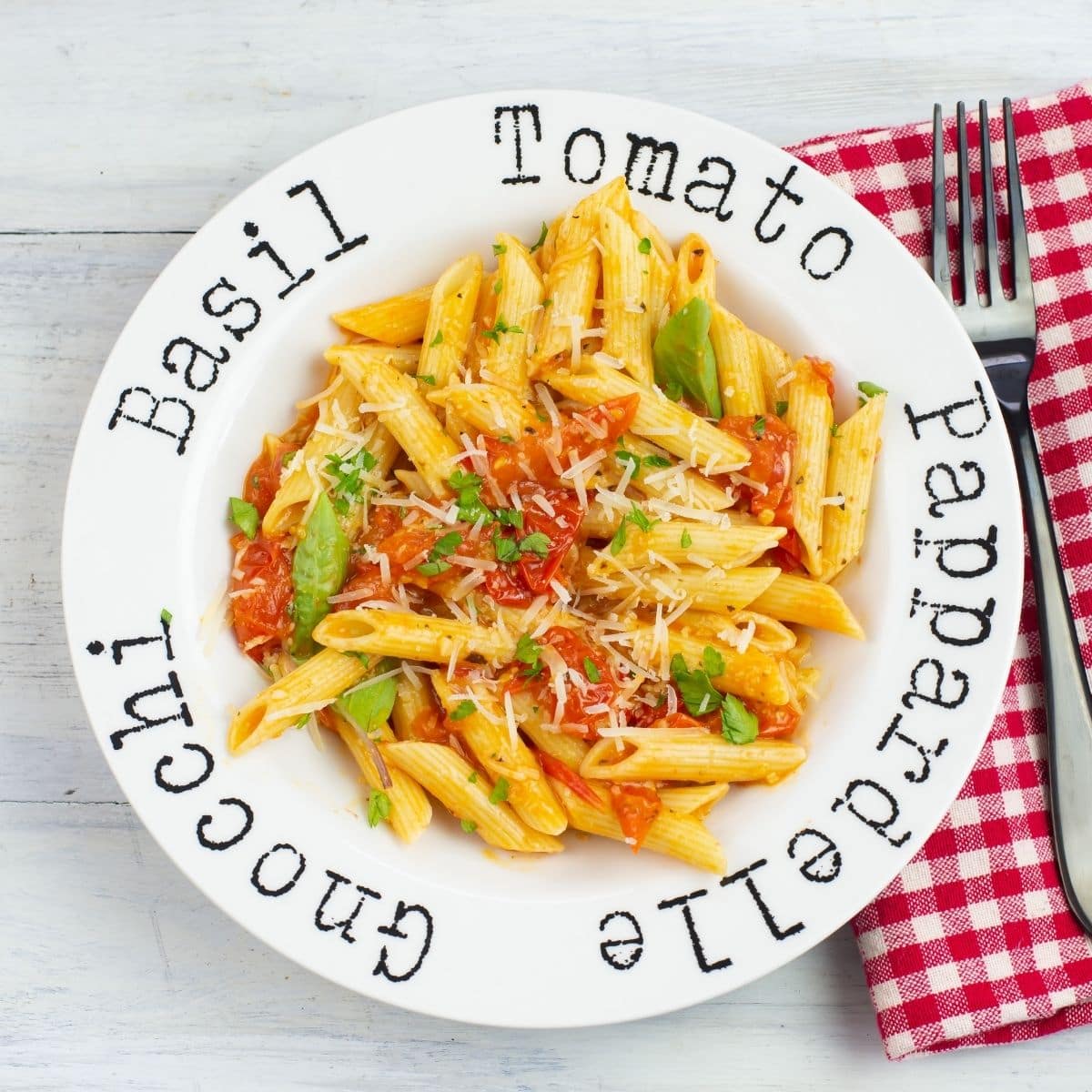 Pasta bowl filled with noodles tossed with cherry tomato sauce.