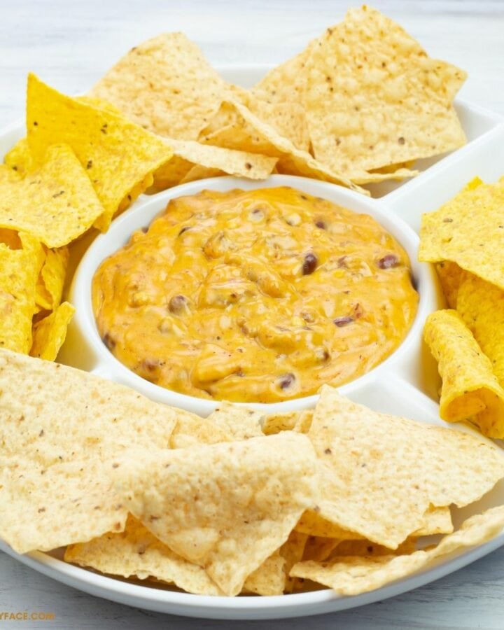 Chili Cheese Dip in a white serving dish with flour and corn chips.