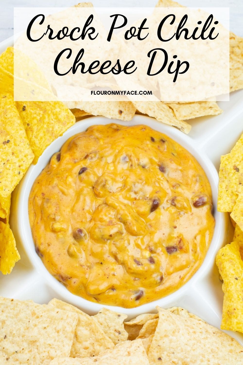 Long vertical image of a chip serving dish filled with chili cheese dip and chips.