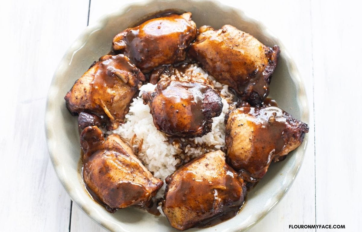Balsamic Chicken over white rice on a plate.