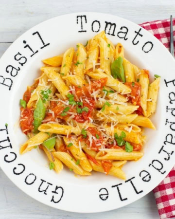 Pasta bowl filled with noodles tossed with cherry tomato sauce.