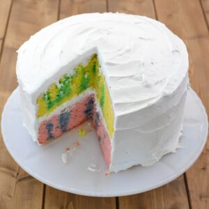 Easter Jello Poke Cake with a slice cut on a cake stand.