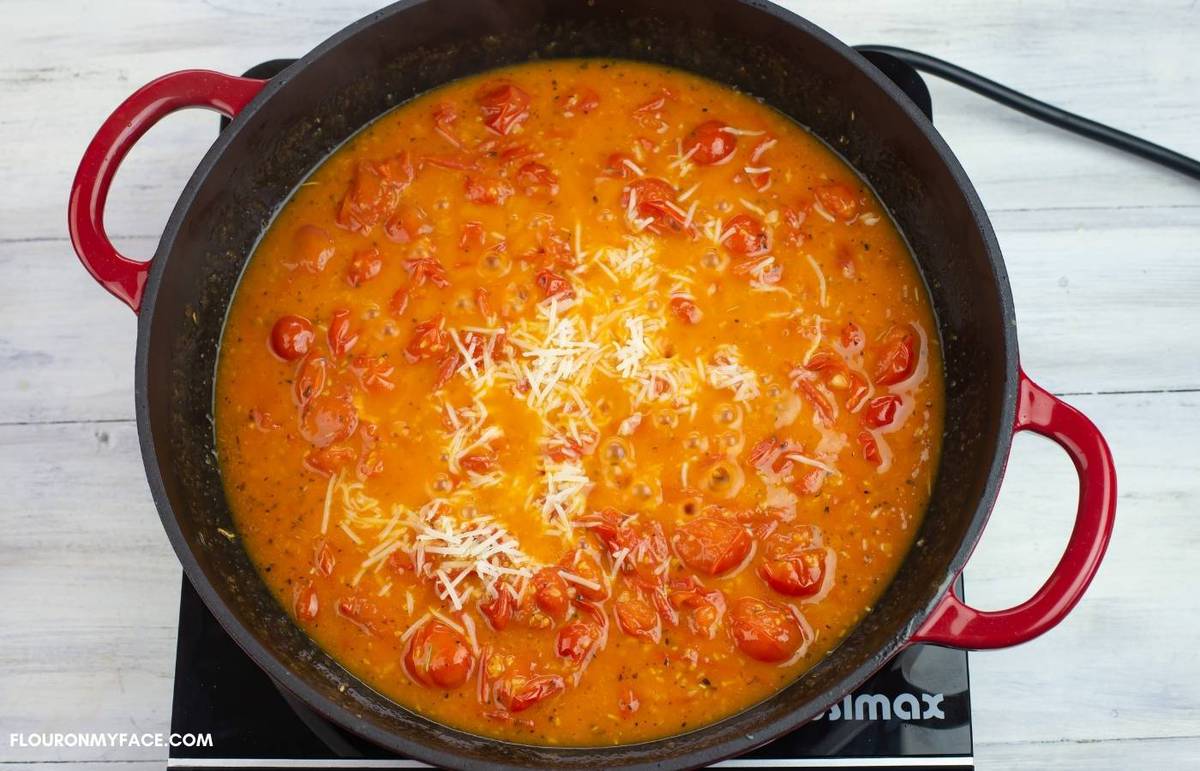 Homemade tomato sauce with a sprinkle of cheese in a skillet.