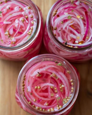 Overhead image of quick pickled red onions in jars.