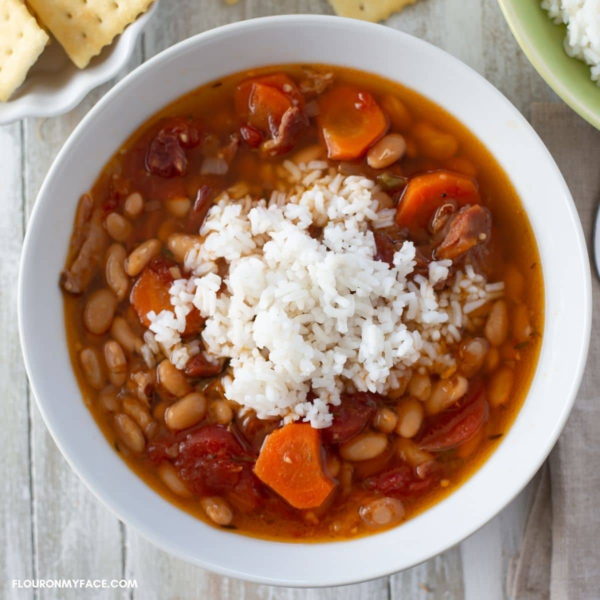 Ham and white bean soup topped with white rice in a serving bowl.