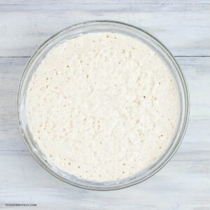 Overhead photo of a glass jar filled with active sourdough starter.