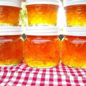 Stacked canning jars filled with citrus marmalade.