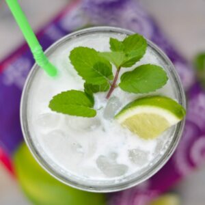 Coconut Mojito in a glass with mint and lime wedge.