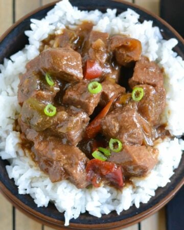 Tender beef pepper steak served over rice in a bowl.