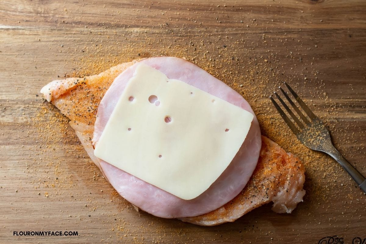 Filling chicken cordon bleu with ham and Swiss cheese.