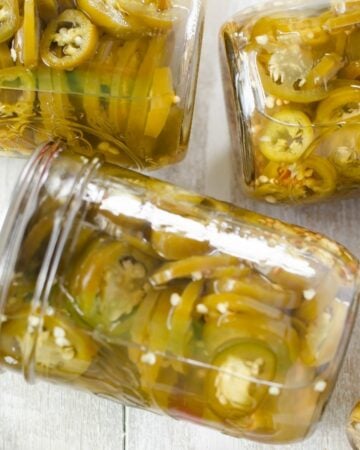 Canning jars filled with pickled jalapeno peppers.