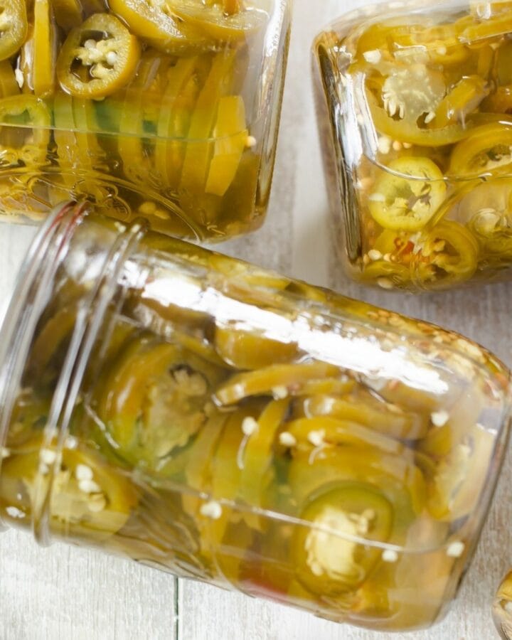 Canning jars filled with pickled jalapeno peppers.