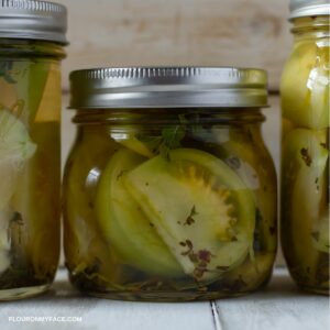 Closeup photo of a mason jar filled with pickled green tomatoes.