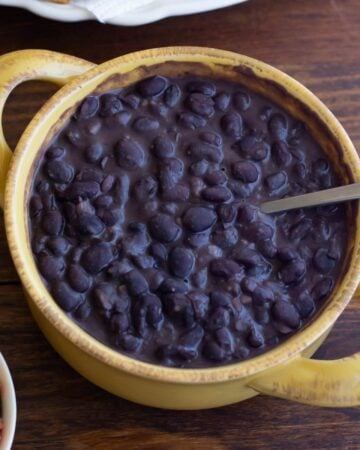 a crock filled with homemade refried black beans on a table.