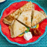 Shredded Beef Quesadillas with salsa and sour cream on a plate.