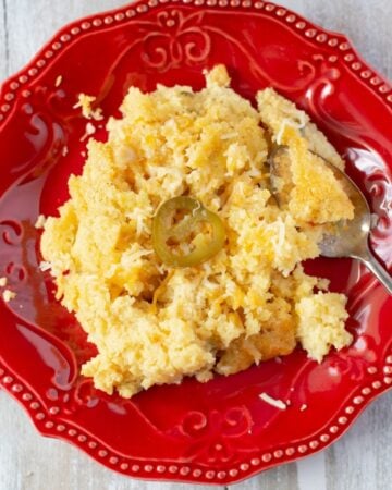 Southern style spoon bread on a red plate.