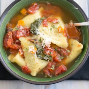 Spinach Ravioli Soup in a green bowl.