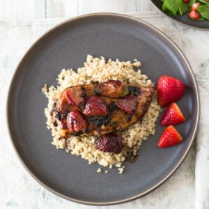 Balsamic Chicken with strawberries served on a bed of quinoa.