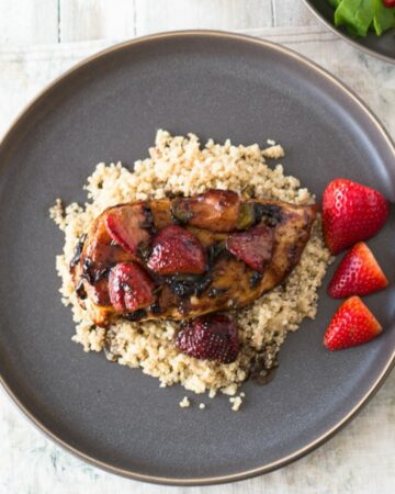 Balsamic Chicken with strawberries served on a bed of quinoa.