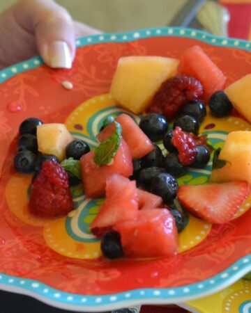 A plate with a serving of summer fruit salad.
