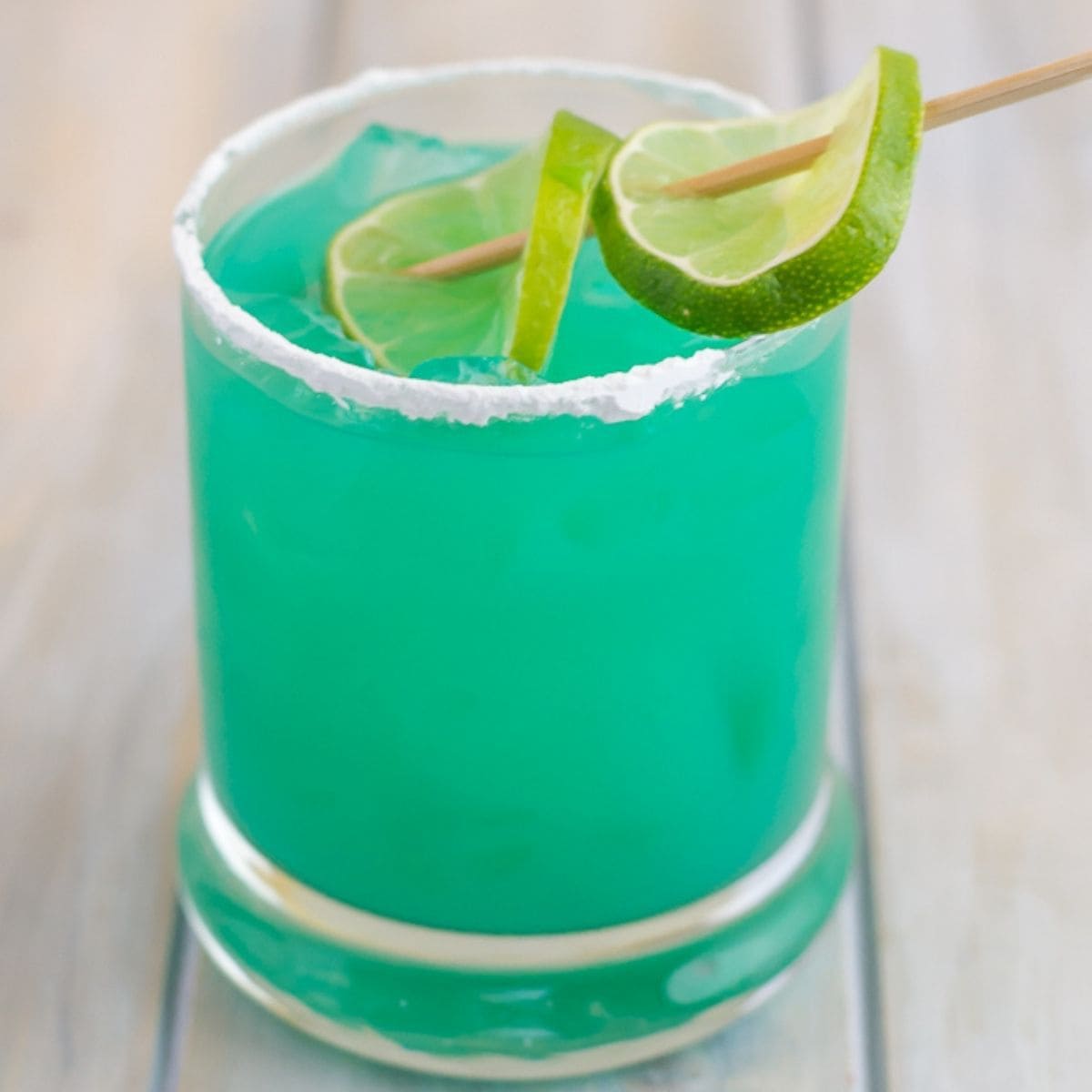 Blue Devil Cocktail served in a highball glass with a lime wedge.