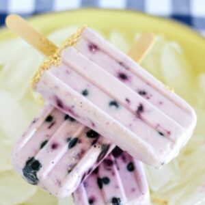 Blueberry Cheesecake Ice Pops stacked on a bed of ice.