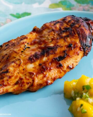 Pineapple Grilled Chicken breast on a dinner plate with mango salsa.