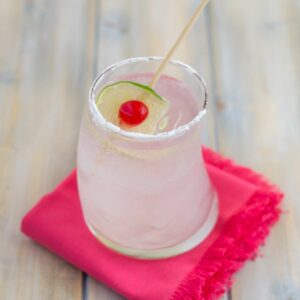 Coconut Rum Cobbler cocktail served in a hugball galss with cherry and lime garnish.