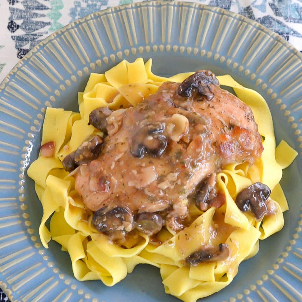 Chicken Marsala served over noodles in a bowl.