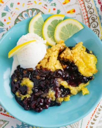 Blueberry Lemon Dump Cake with a scoop of vanilla ice cream in a bowl.