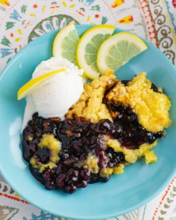 Blueberry Lemon Dump Cake with a scoop of vanilla ice cream in a bowl.