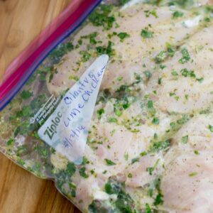 A freezer bag filled with cilantro lime marinated chicken breasts.