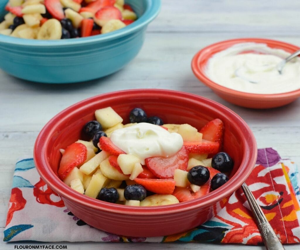 A bowl of fresh fruit topped with sweetened crème fraiche.