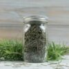 Dehydrated rosemary in a glass spice bottle.