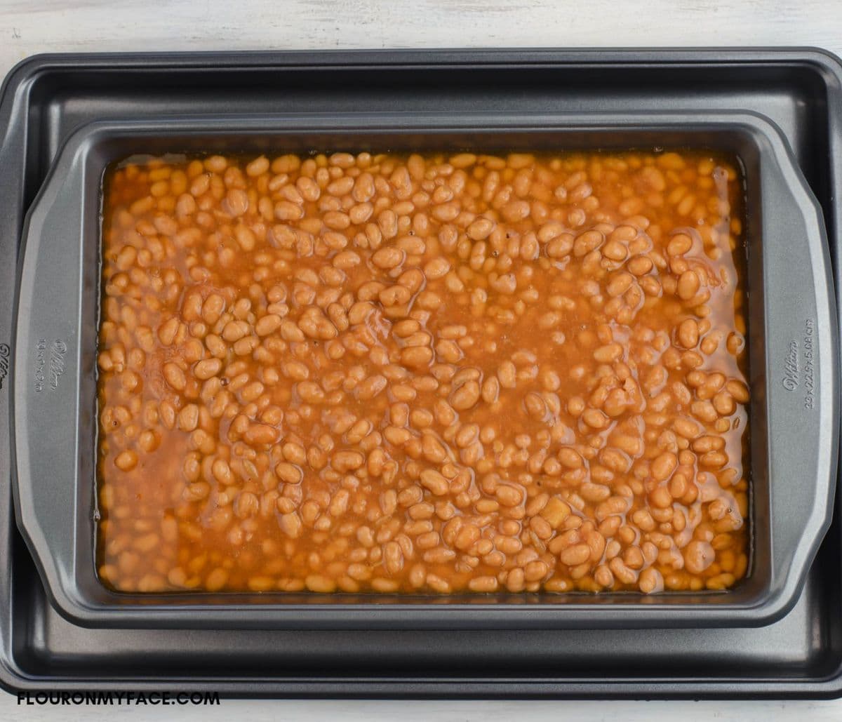 Canned pork and beans in a 9 x 13 baking pan.