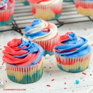 3 cupcakes decorated with red white and blue buttercream frosting.