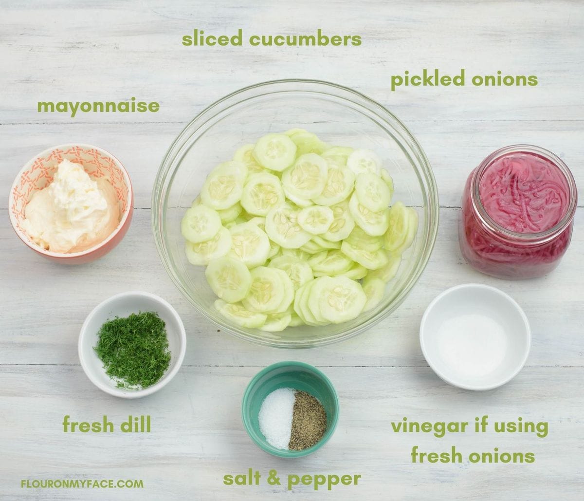 Creamy cucumber salad ingredients in individual bowls.