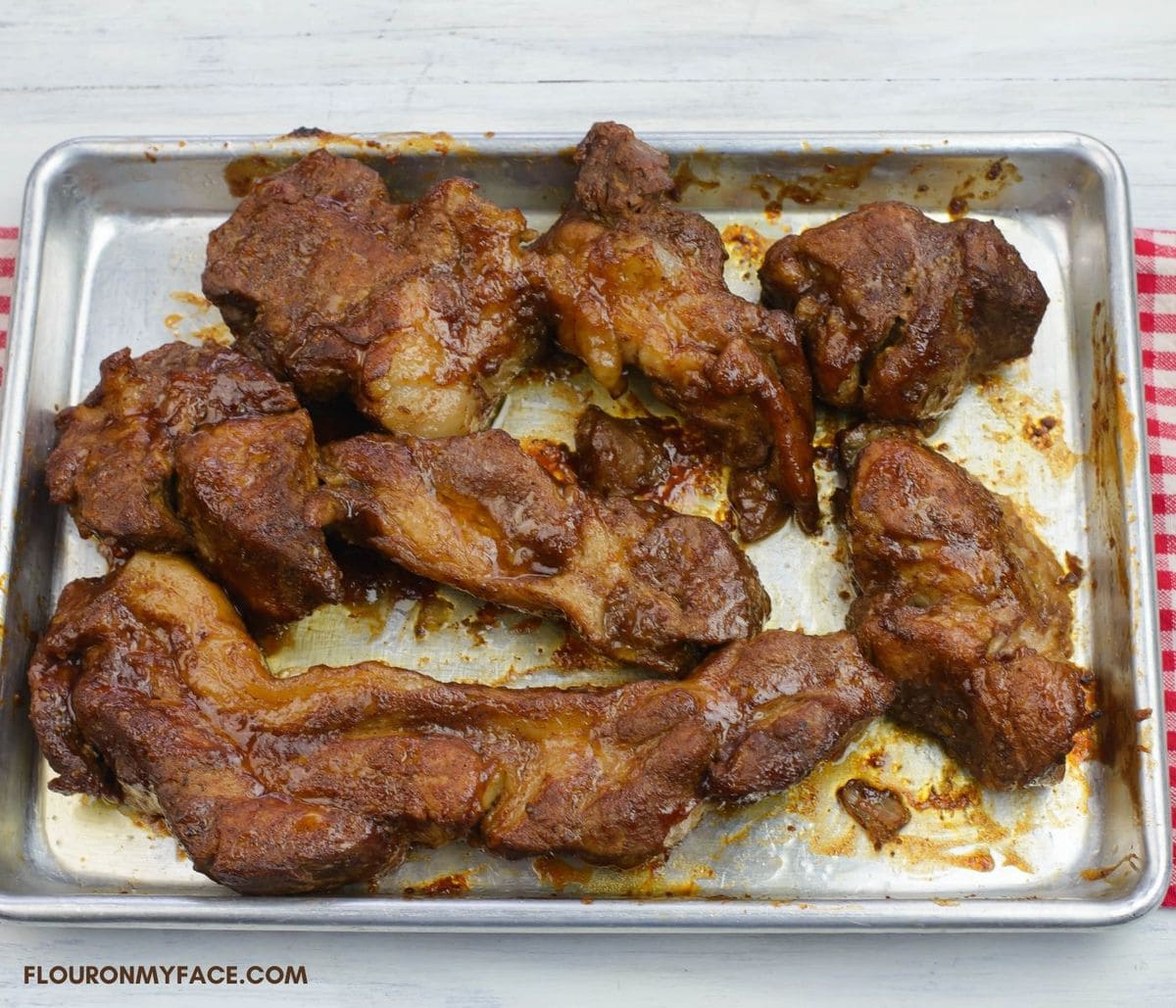 Overhead image of a baking tray with barbecued country style pork ribs that have been pressure cooked.