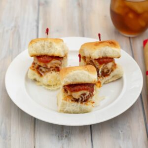 A white plate with 3 sliders made with homemade meatballs.