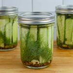 Closeup photo of a half pint mason jar filled with refrigerator garlic dill pickles.