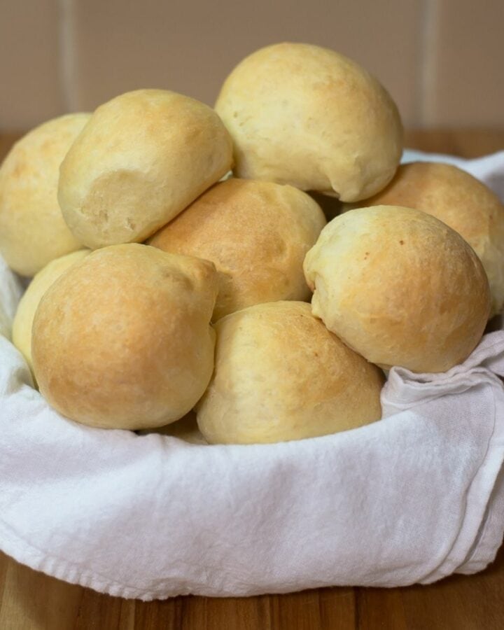 A towel lined basket filled with homemade slider buns.