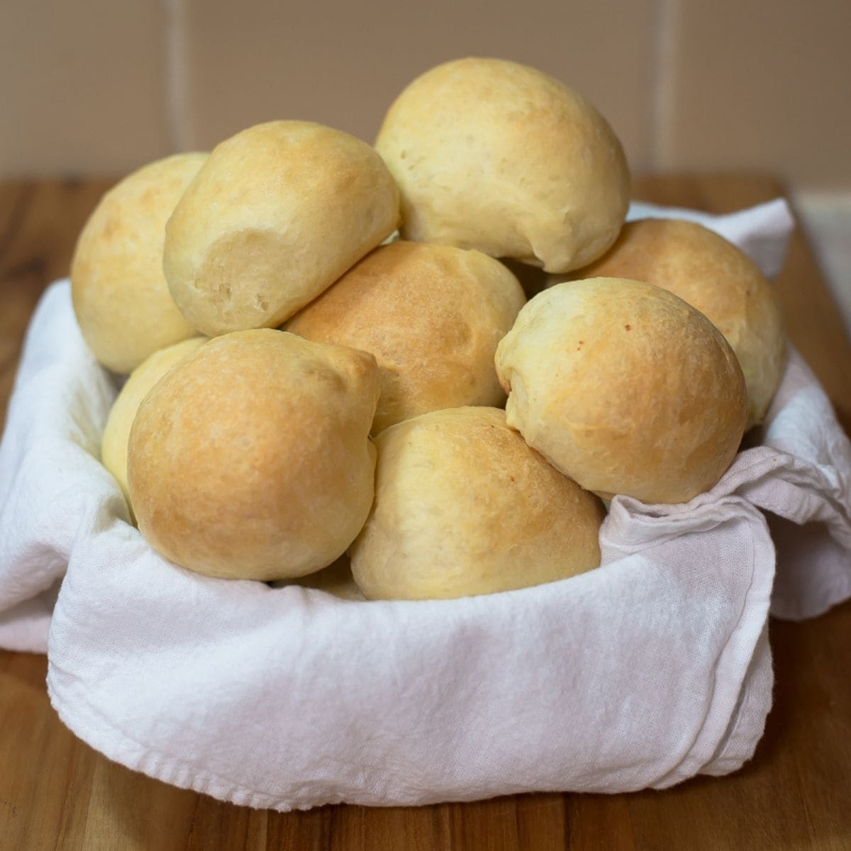 A towel lined basket filled with homemade slider buns.