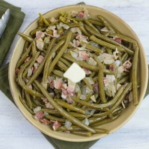 A large serving bowl filled with crock pot green beans with bacon.