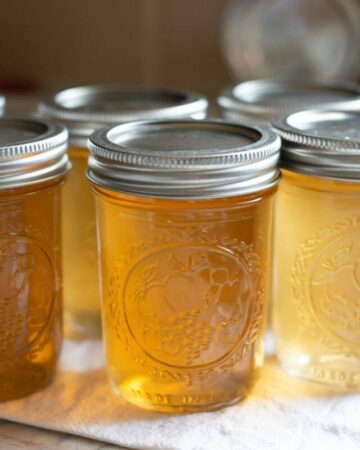 Hakf pint jelly jars filled with muscadine jelly on the counter after hot water bath processing.