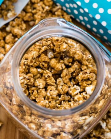 Overhead image of a glass candy jar filled with homemade caramel corn.
