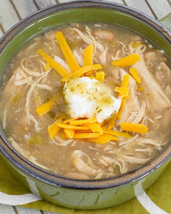 A green bowl filled with white chicken chili.