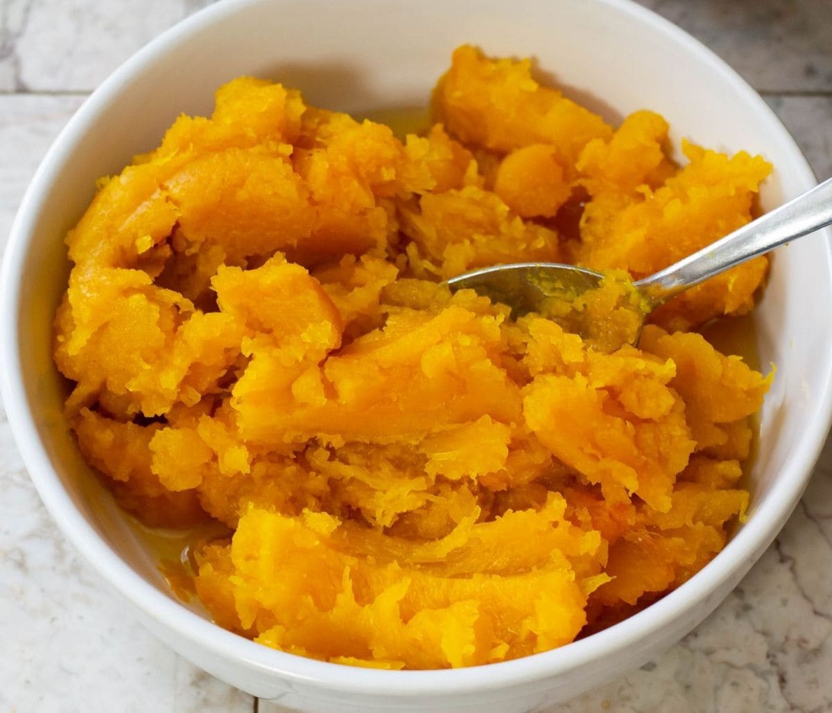 A overhead image of a bowl filled with pumpkin puree.