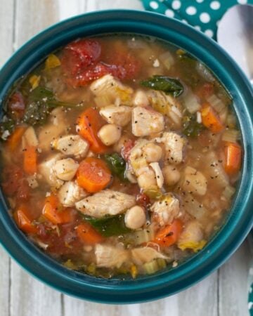 A bowl filled with chunky chicken garbanzo bean soup.