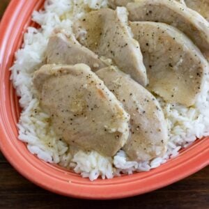 Creamy Cajun Pork Chops slow cooked and served on a bed of white rice.